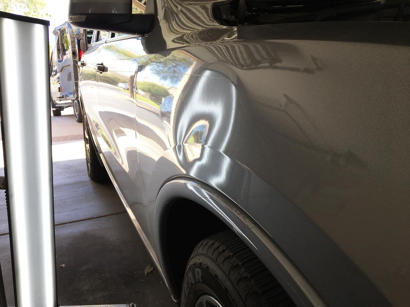 Gray truck fender with dent before paintless dent repair