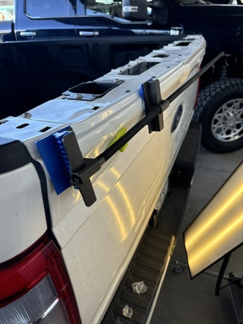 PDR repair bars clamped to white van panel in garage